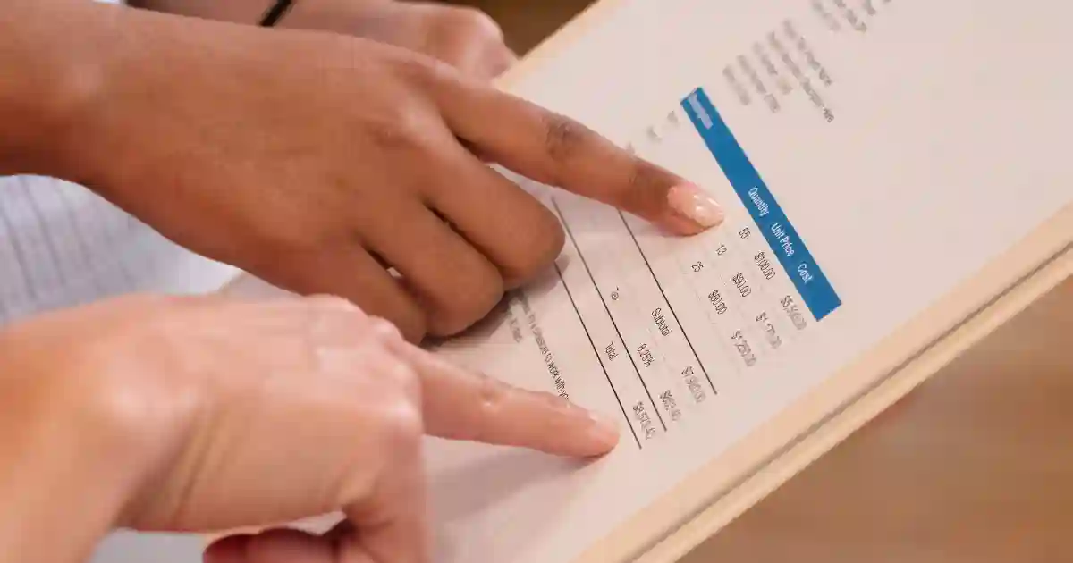 UK tradesperson reviewing a job quote on a clipboard, calculating pricing for a trade job