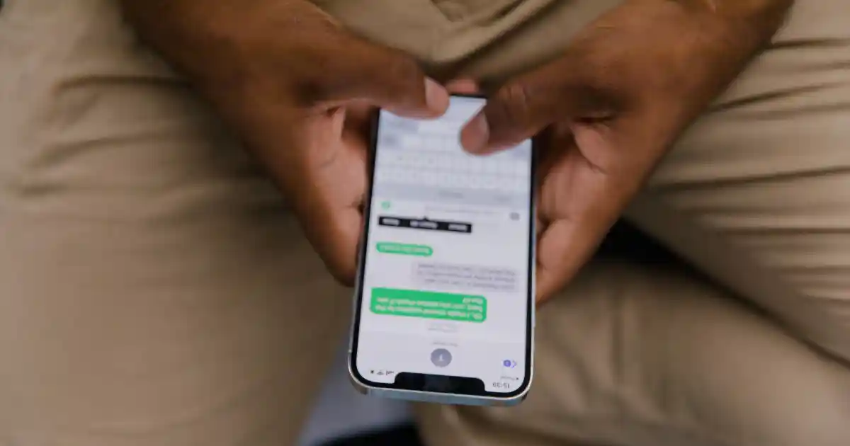 UK tradesperson on a smartphone sending a personalised automated SMS template reply to a missed call
