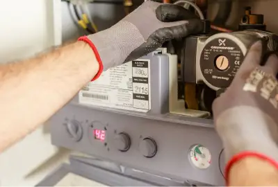 Gas safe engineer servicing boiler in UK home