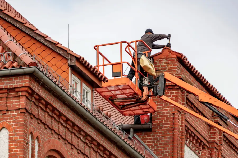 UK roofer repairing roof tiles